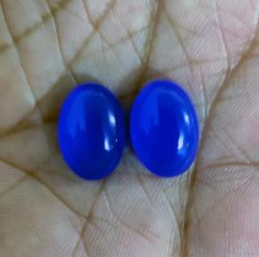 two blue balls sitting on top of a persons hand