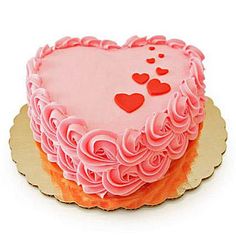 a heart shaped birthday cake with pink frosting