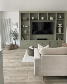 a living room filled with furniture and a flat screen tv mounted on a wall above a fireplace