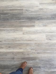 a person standing on the floor with their feet propped up in front of them and wearing sandals