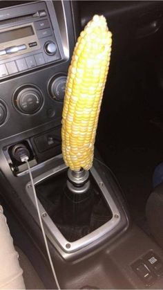 a corn cob sitting on top of an electronic device in a car's dashboard