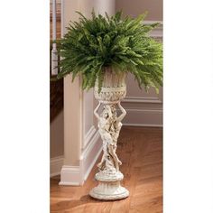 a plant in a white vase on top of a wooden floor next to a doorway