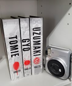 two books and a camera on a shelf