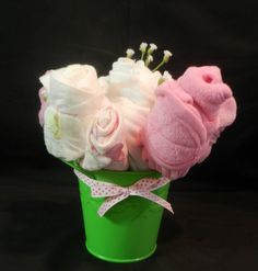 a green bucket filled with lots of pink and white diapers on top of a black background