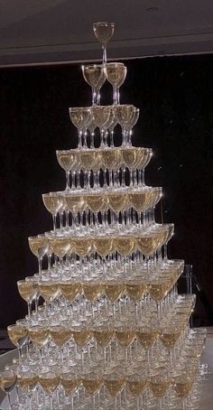 a large stack of wine glasses sitting on top of a table