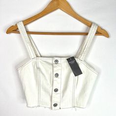 New With Tags Abercrombie & Fitch White Denim Button Up Tank Top With Adujustable Straps And Raw Hem. Can Be Worn As Is Or Styled Like A Corset Top Over Other Shirts. Super Cute! Size Extra Small. Shoulder-Hem: 14" Armpit-Armpit: 15" Waist: 13" Trendy White Top With Snap Buttons, Trendy White Denim Tops, White Denim Top For Day Out, White Denim Tops For Spring, Spring White Denim Top, White Cropped Top With Buttons, Chic White Denim Tops, Button Up Tank Top, Abercrombie (women)