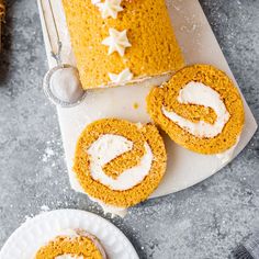 two slices of pumpkin roll with cream cheese frosting on top and one slice cut out