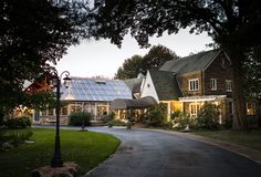 a house with a solar panel on the roof is lit up at night in front of it