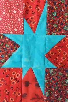 a red and blue quilt with a star on it