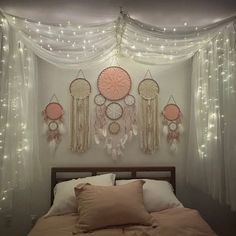 there is a bed with some lights on the headboard and curtains hanging above it