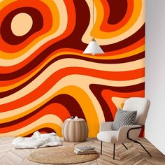 an orange and red wall mural in a living room next to a white chair with a rug on the floor