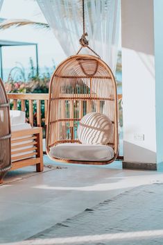 a rattan swing chair hanging from the ceiling