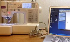 an open laptop computer sitting on top of a wooden desk next to a sewing machine