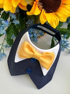 a close up of a flower with a bow tie and sunflowers in the background