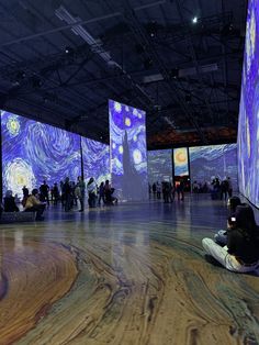 people are sitting on the floor in front of large screens with images of starrdusts