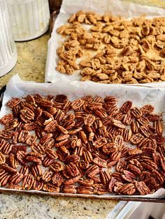 two trays filled with pecans sitting on top of a counter