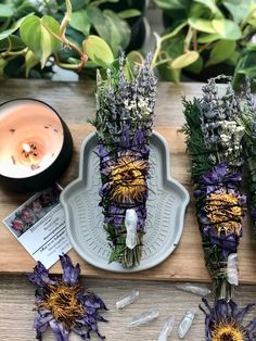 lavender flowers are arranged on a tray next to a tealight candle and some plants