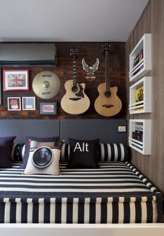 a bed with guitars on the wall above it