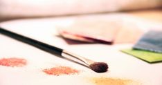 a close up of a brush on a table next to some colored paper and other items