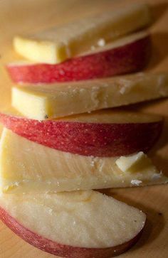 four slices of apple sitting on top of a wooden cutting board