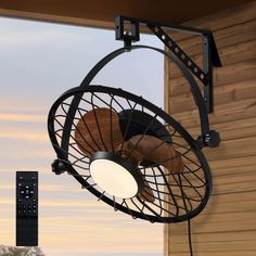 a black fan sitting on top of a wooden wall