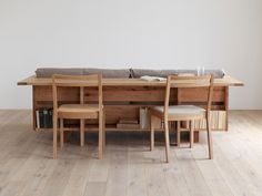 a wooden table with four chairs and a bench in front of it on top of a hard wood floor