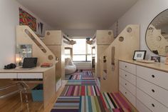 a room with bunk beds and desks in it