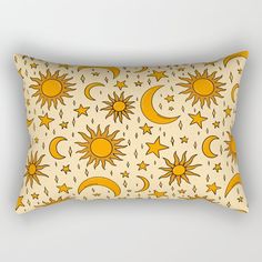 a yellow and white pillow with sun, moon and stars on it