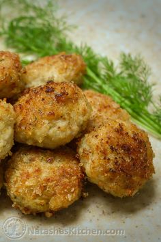 some fried food is on a white plate with green garnish and parsley