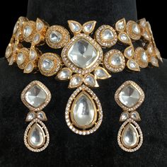 Polki Necklace, inspired by Sabyasachi, features Moissanite and Kundan diamonds set in uncut Polki with a delicate design. Rose gold-plated for a touch of elegance, it embodies a blend of traditional and modern aesthetics. Ideal for bridal jewelry, it adds a sophisticated, faux diamond sparkle to any ensemble. *𝐏𝐑𝐎𝐃𝐔𝐂𝐓 𝐃𝐄𝐓𝐀𝐈𝐋* * Material: Brass * Plating: Rose Gold Plated * Stone: Semi Precious Polki, Kundan & CZ.  *𝐃𝐈𝐌𝐄𝐍𝐒𝐈𝐎𝐍𝐒* * Necklace- Weight: 68 gm,  Design Length-6.3 Glamorous Gold Sets For Festivals, Formal Gold Sets With Mirror Work, Glamorous Festive Jewelry For Reception, Glamorous Festive Necklaces For Celebrations, Glamorous Festive Celebration Necklaces, Elegant Necklace With Mirror Work For Festive Occasion, Elegant Necklace With Mirror Work For Party, Glamorous Stone Work Jewelry For Wedding, Glamorous Jewelry With Stone Work For Wedding