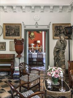 a living room filled with furniture and pictures on the wall above it's doorway