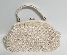 Fantastic expanding top handle frame bag with faux leather trim and golden clasp. The charming cotton toile interior has a small interior zipper pocket and feels like it has an interior vinyl interlining for structure. The beautiful raffia is crocheted in a charming popcorn pattern. The interior and exterior are in fine vintage condition. The bag frame edge has various nicks in the faux leather. Please see photos for details. On the bottom of the bag the is one brown slice of raffia. It looks intrinsic to the weave, not a stain. Please see photos for details. Height: 9 in Length: 14 in Width: 6 in Weight: 1 lb 7 oz Please reach out with any questions. We have free shipping in the USA and will combine international shipping on multiple orders. Any shipping overages will be cheerfully refund Elegant Crochet Bag For Spring Evenings, Elegant Crochet Evening Bag For Spring, Elegant Evening Crochet Bag For Spring, Vintage Clutch Bags For Spring, Vintage Crochet Bag For Spring, Elegant White Handheld Crochet Bag, Elegant Cream Crochet Bag For Spring, Vintage Formal Bag For Spring, Vintage Formal Bags For Spring