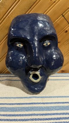 a blue mask with an open mouth on top of a table