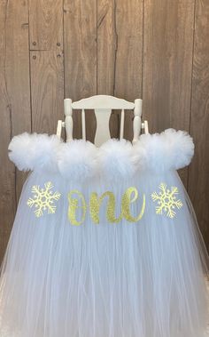 a white tutu skirt with gold snowflakes and the word noel on it