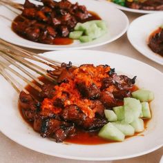 several plates of food with chopsticks in them and meat on the plate next to each other