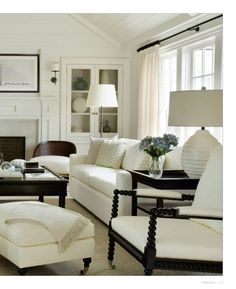 a living room filled with white furniture and a fire place in the centerpieces