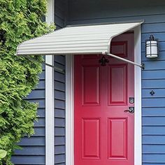 a red and blue door with a white awning on the side of a house