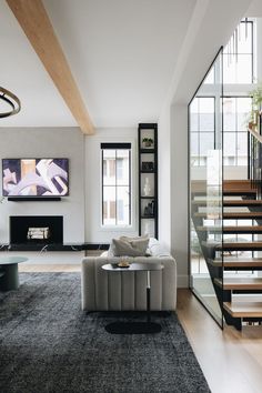 a modern living room with stairs leading up to the second floor