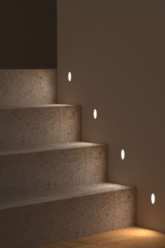 some lights that are on the side of stairs