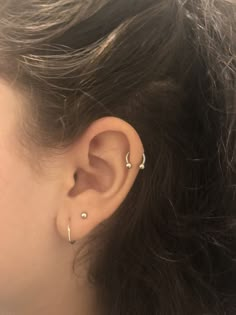 a close up of a person's ear with two piercings on top of it