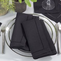 the place setting is set with black napkins and silverware