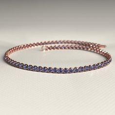 Add a breathtaking touch to your ensemble with this exquisite Tanzanite Tennis Bracelet. Skillfully handcrafted using high-quality 14K/18K gold, this custom stacking bracelet is perfect for everyday wear or special occasions. Adorned with stunning Tanzanite gemstones, this December birthstone bracelet is a must-have for any jewelry lover. It also makes a thoughtful Christmas gift that will surely impress. Don't miss out on our exclusive Cyber Sale and treat yourself or a loved one today!𝐅𝐞𝐚𝐭 Elegant Tanzanite Bracelets For Formal Occasions, Formal Tanzanite Bracelets Fine Jewelry, Formal Tanzanite Fine Jewelry Bracelets, Fine Jewelry Tanzanite Bracelets For Gift, Round Tanzanite Bracelets For Formal Occasions, Formal Tanzanite Round Bracelets, Formal Single Strand Round Bracelet, Tanzanite Gemstone Bracelet For Anniversary, Adjustable Gold Bracelet With Gemstone For Formal Occasions