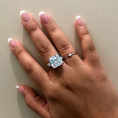 a woman's hand with a ring on it and a diamond in the middle