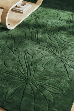 a green rug on the floor next to a chair