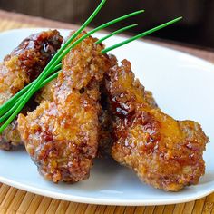 oven baked double crunch kong pao wings on a white plate with green scallions