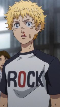 a man with blonde hair wearing a rock t - shirt in front of other men