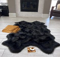 a black sheepskin rug on the floor in front of a fireplace