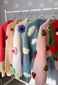 several sweaters hanging on a rack in a room