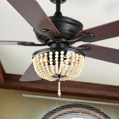 a ceiling fan with beads hanging from it's blades in a living room area