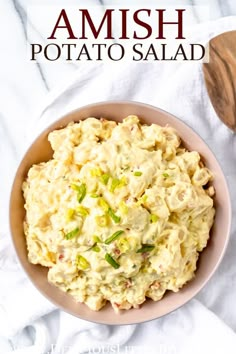 a bowl filled with potato salad on top of a white table